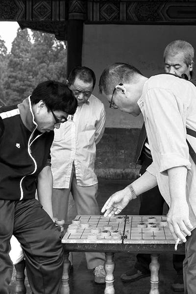 Grupo de homens a conviver enquanto jogam jogos de tabuleiro, no Yu Garden, em Shanghai.