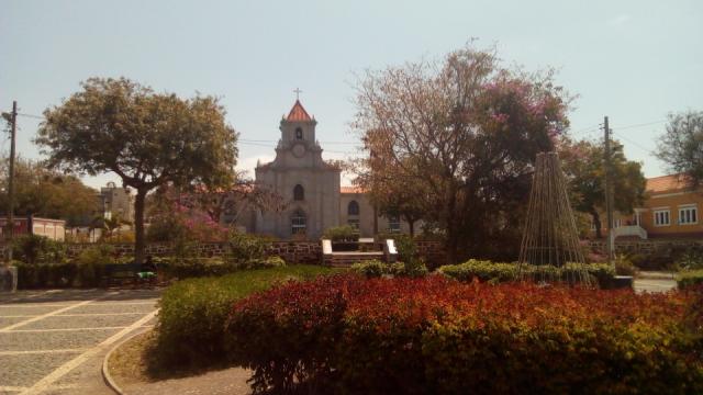 Parque com uma igreja, árvores e flores