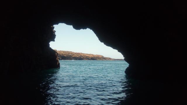 Através do desenho de uma gruta podemos ver o mar e um pedaço de terra.