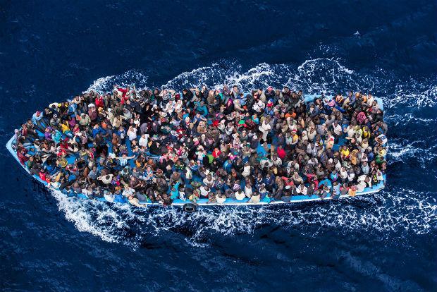 Centenas de refugiados e migrantes a bordo de um barco de pesca são fotografados momentos antes de serem resgatados pela Marinha italiana como parte da operação Mare Nostrum em junho de 2014. Foto: UNHCR/Guarda Costeira Italiana/Massimo Sestini